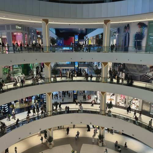 Wide-angle view of shoppers in the luxurious multi-level interior of Dubai Mall, the heart of modern retail.